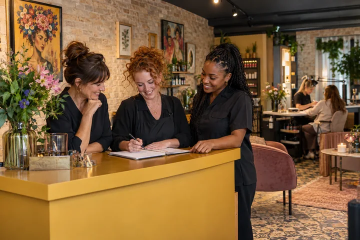 Kollegaer planlægger dagens arbejde sammen i en salon
